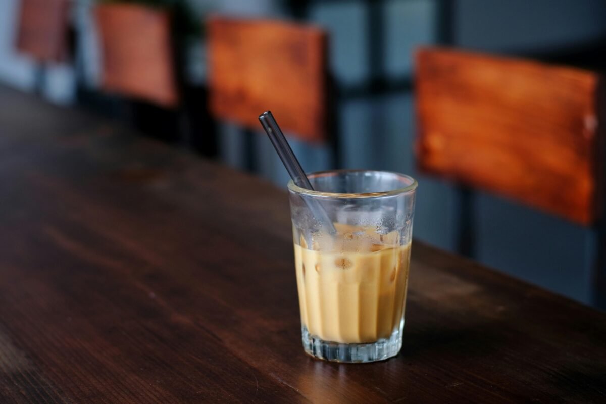 Glass of Coffee and Milk Drink on a Brown Wooden Table